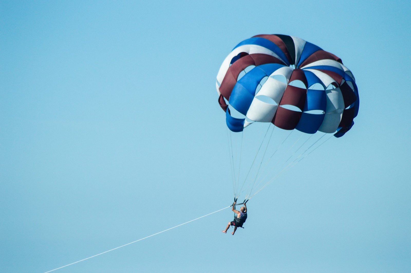 a person is parasailing in the blue sky